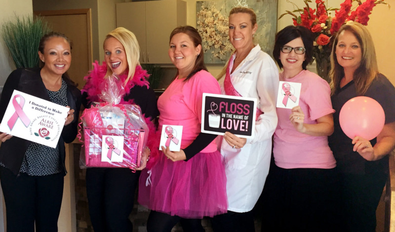 Six Fountains Dental Excellence Team Members posing and smiling to promote breast cancer awareness